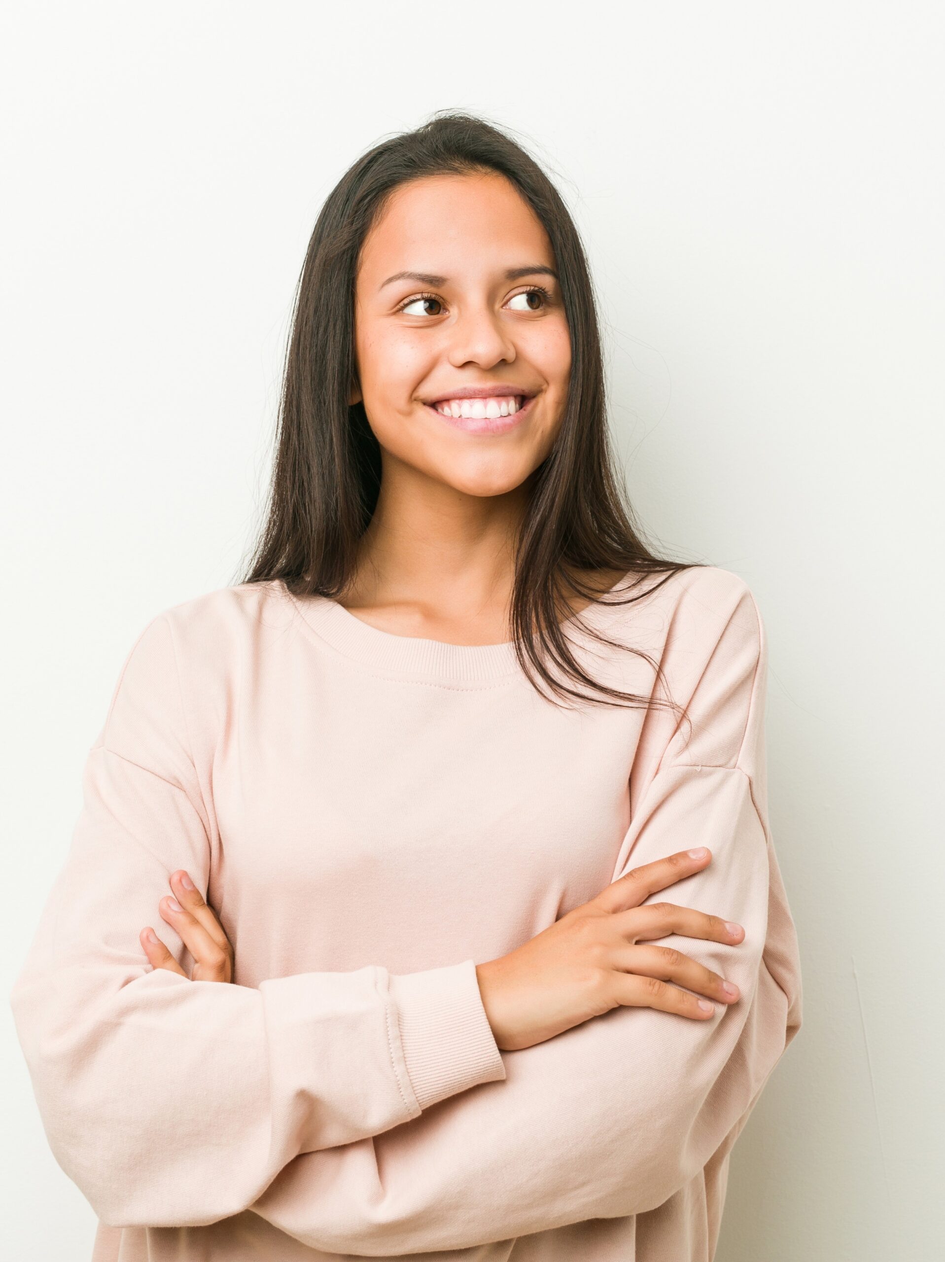 Mujer joven sonriendo segura de sí misma con los brazos cruzados mirando las preguntas frecuentes sobre LASIK