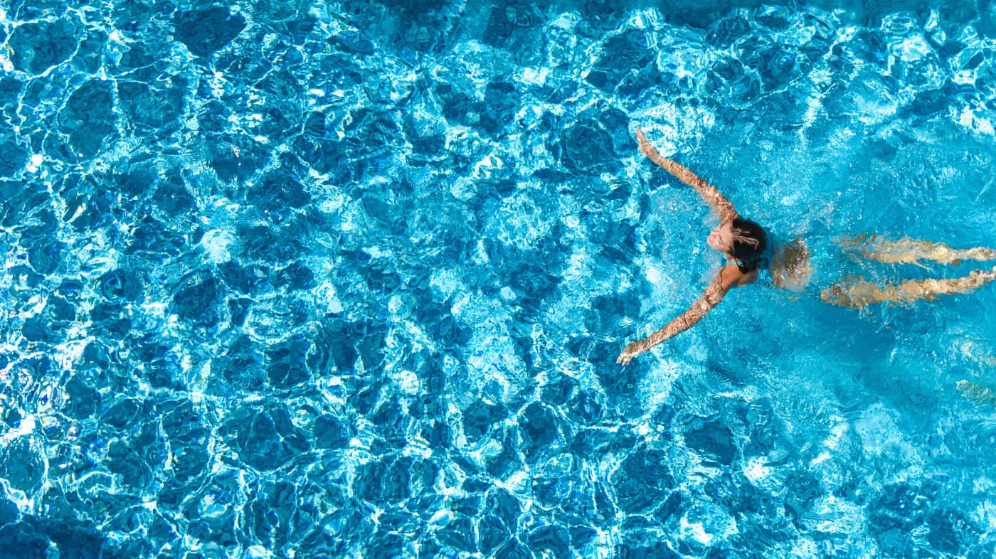 vista de chica activa en piscina desde arriba