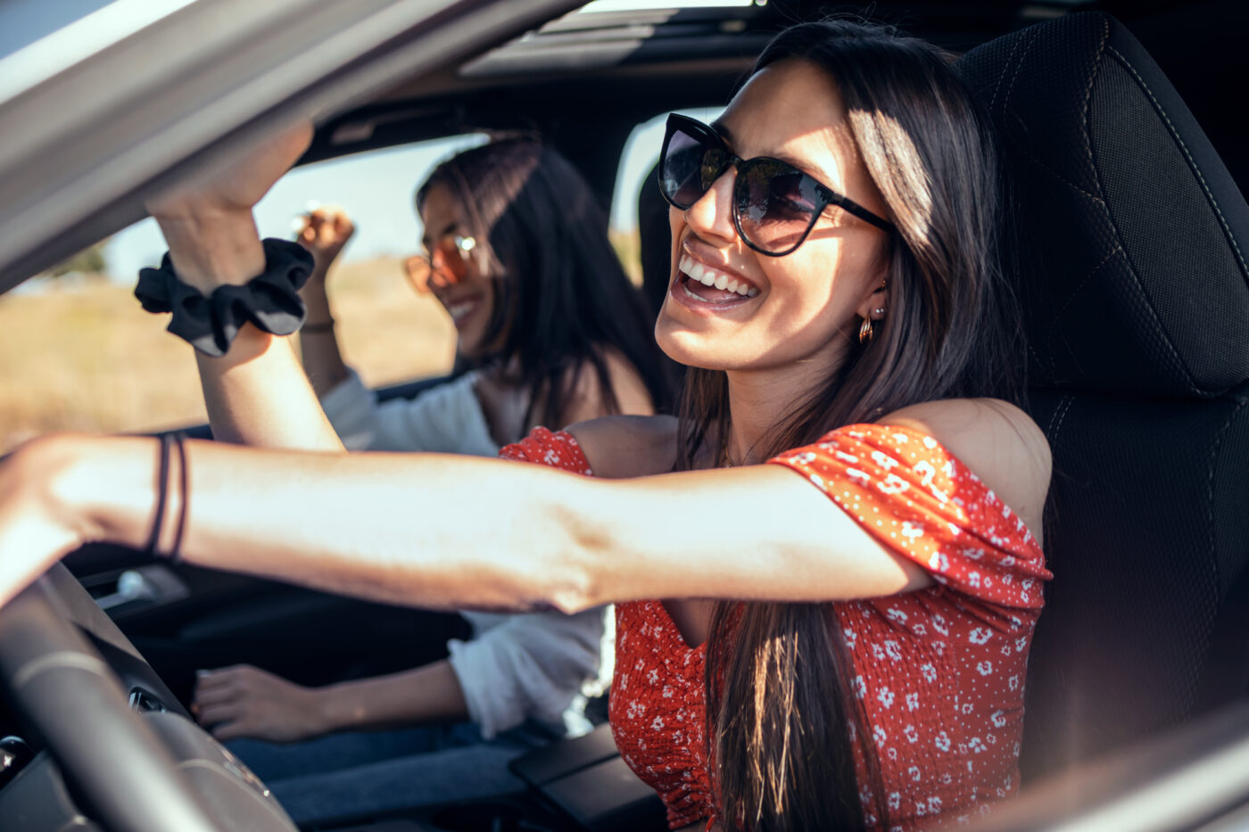 Women in the car smiling while they enjoy a drive