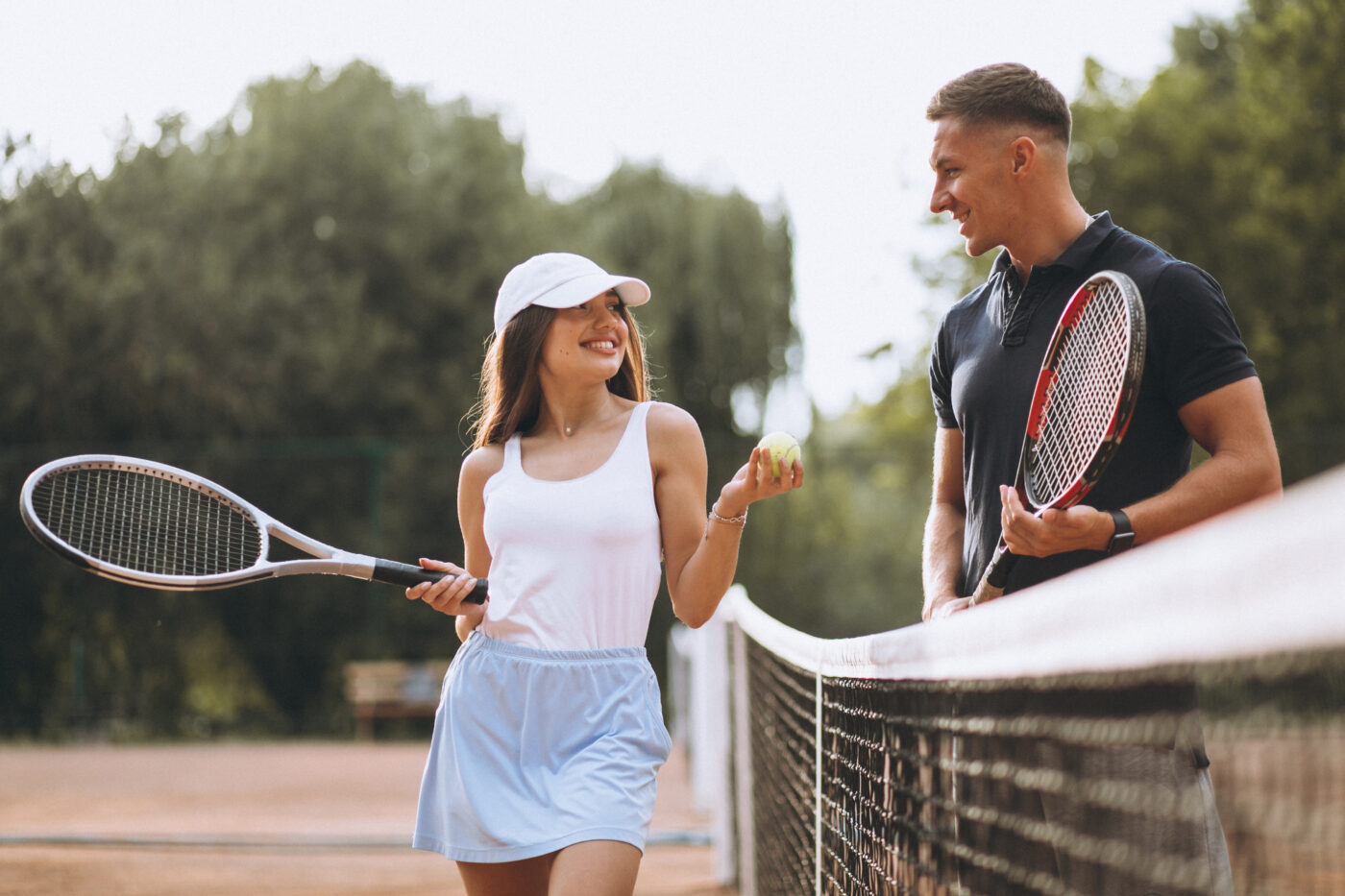 Young couple playing tennis at the court