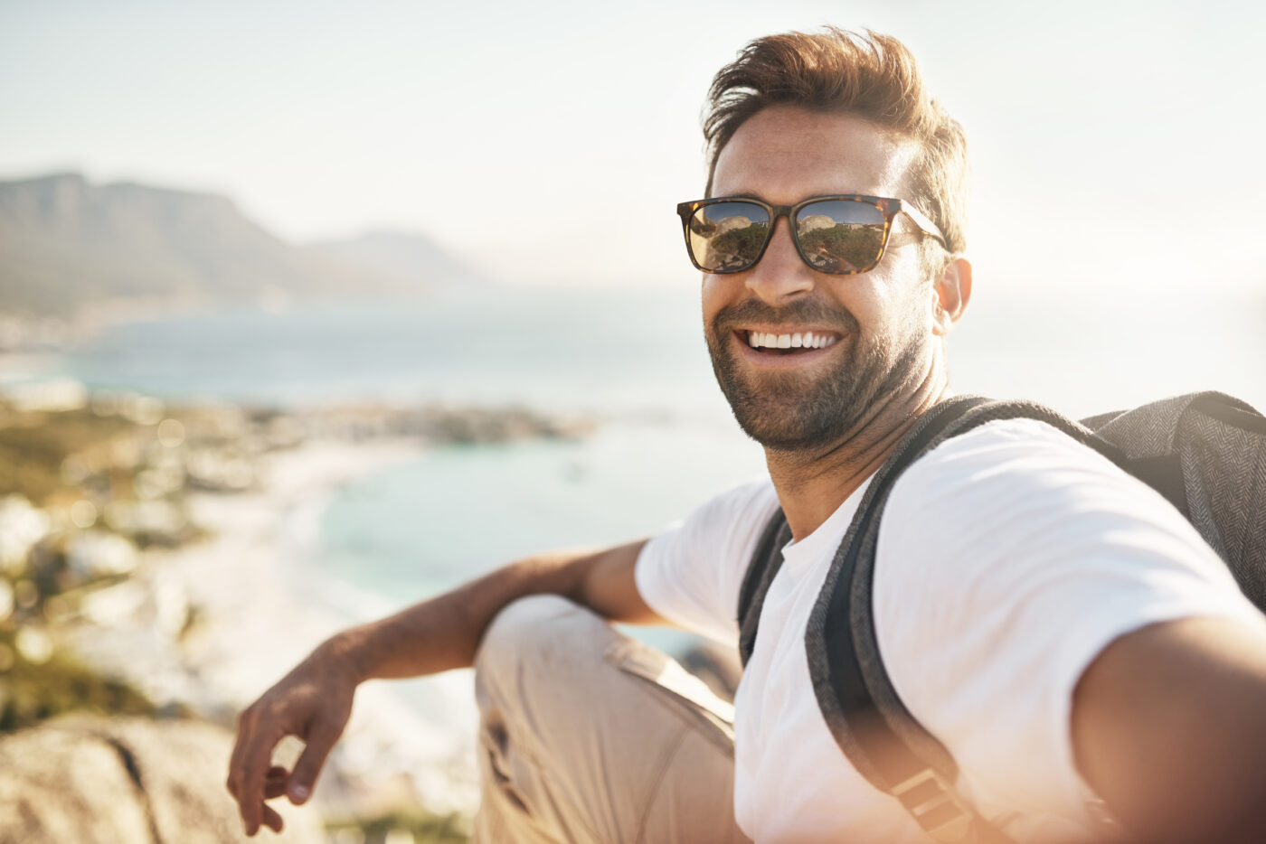 Retrato de un apuesto joven que se hace selfies mientras practica senderismo en la montaña.